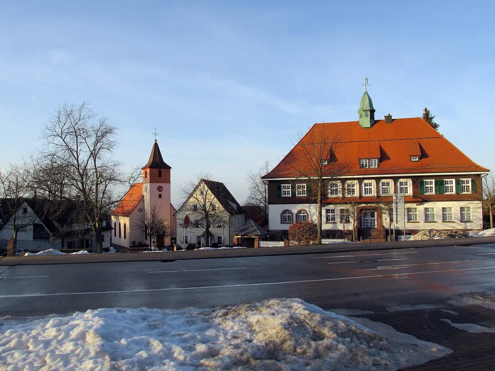 Rathaus und Kirche von Dobel im Nordschwarzwald an einem klaren Wintertag mit Restschnee