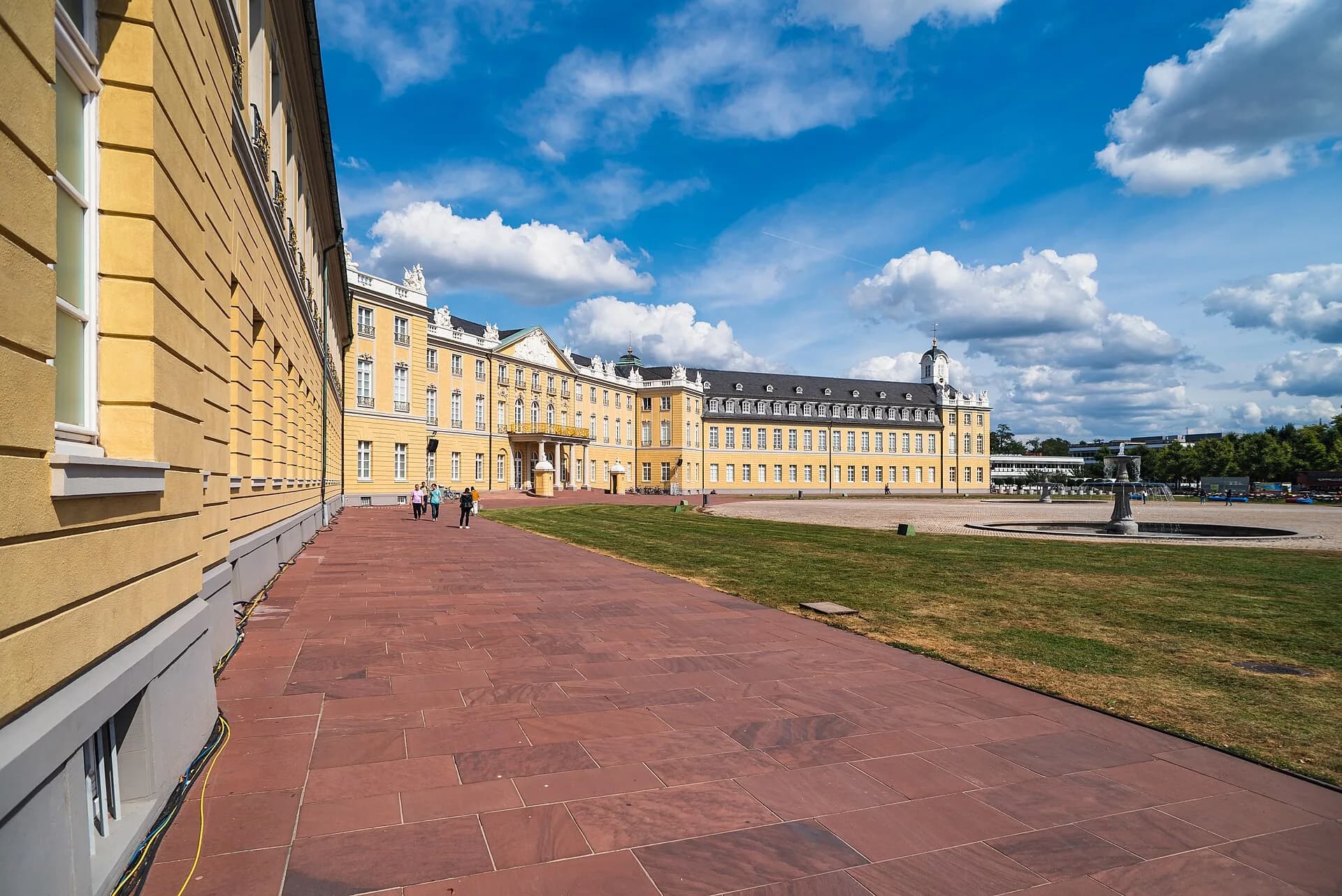 Blick entlang der Fassade des Karlsruher Schlosses mit Schlossgarten davor